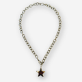 A silver-toned metal chain necklace with a dangling star-shaped pendant, set against a plain light gray background.