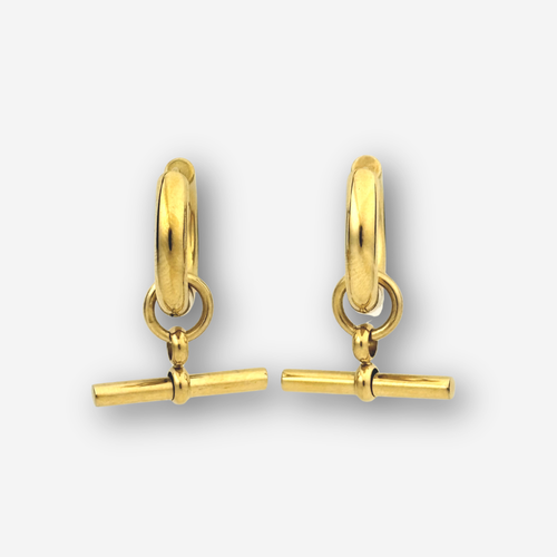 A pair of gold huggie hoop earrings with a toggle bar charm, shown on a light gray background.