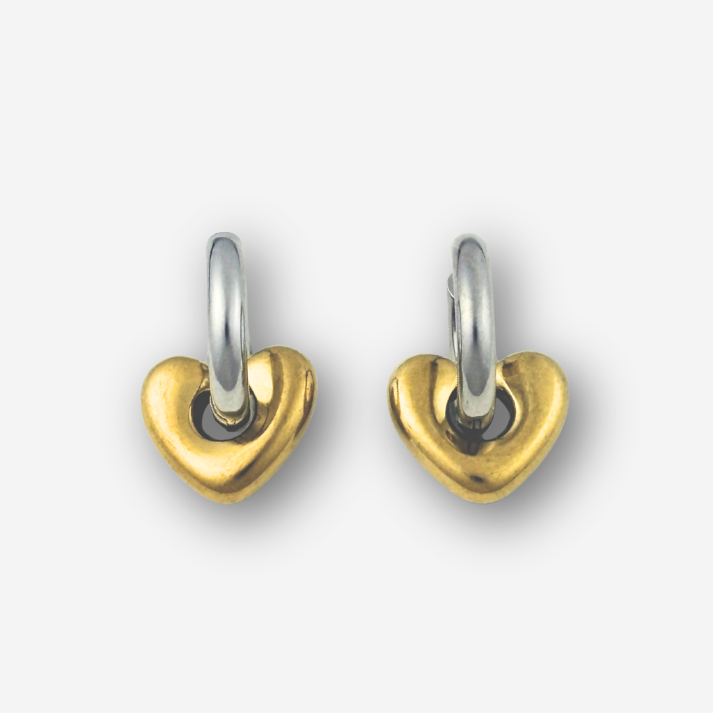 Pair of heart-shaped earrings with gold and silver finish on a white background
