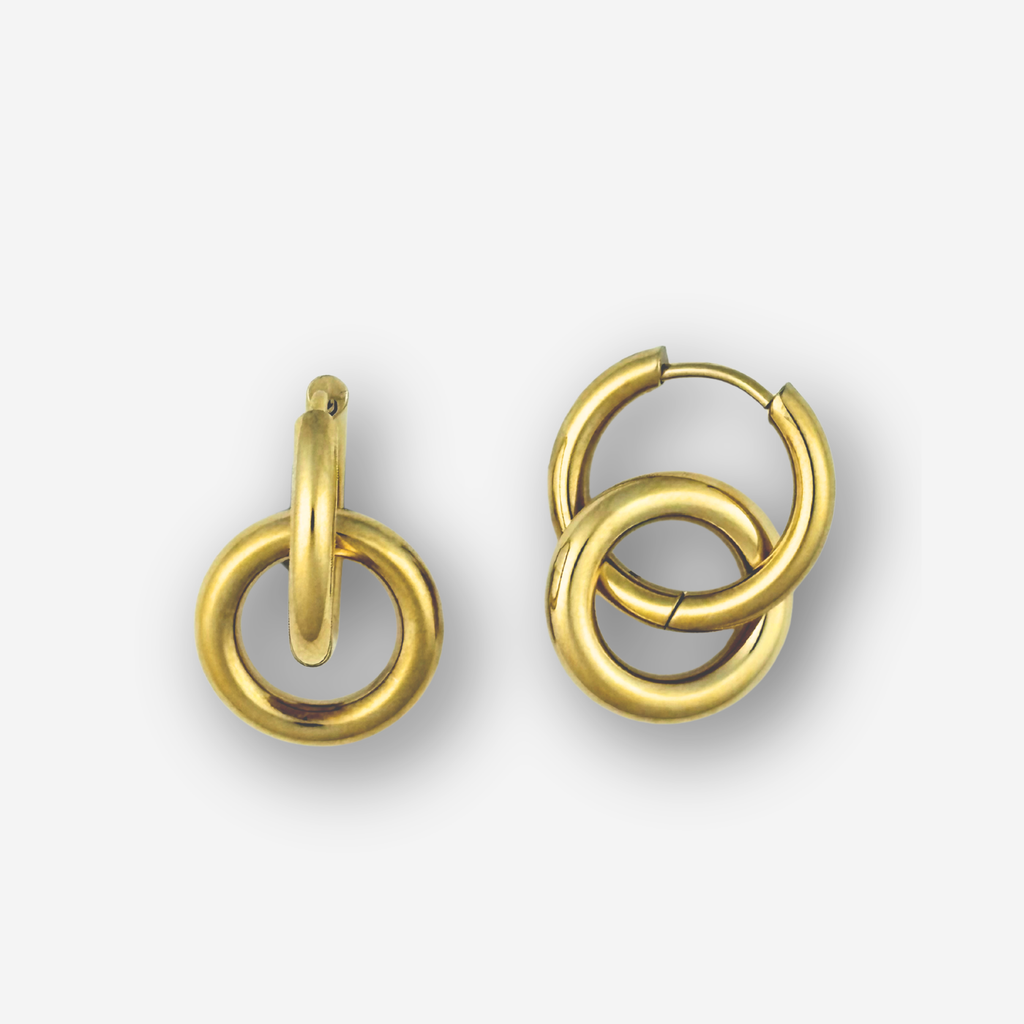 Double circle gold hoop earrings on a light grey background