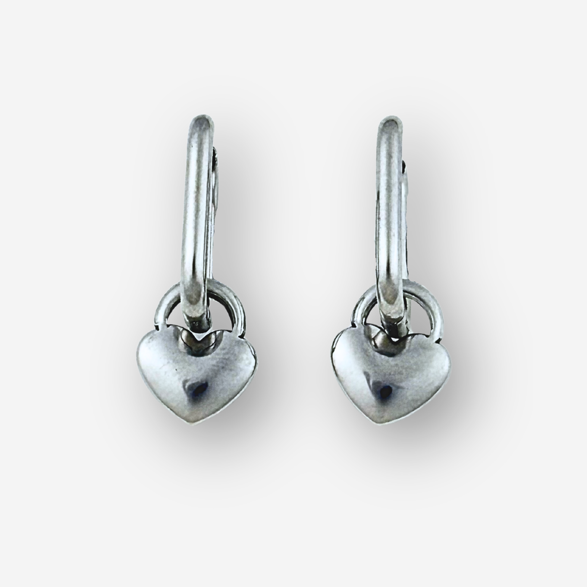 Pair of silver heart-shaped earrings on a white background