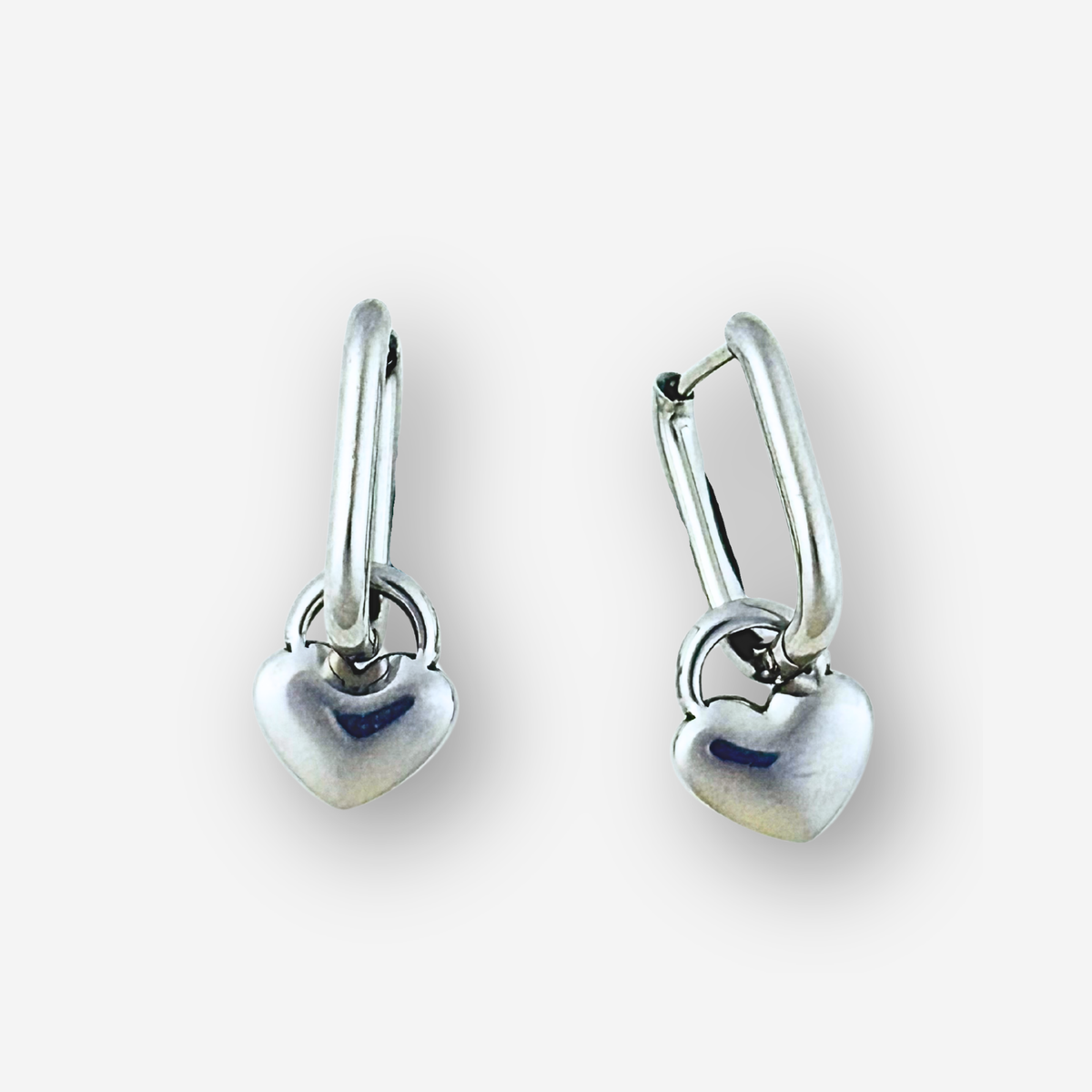 Pair of silver heart-shaped earrings on a white background