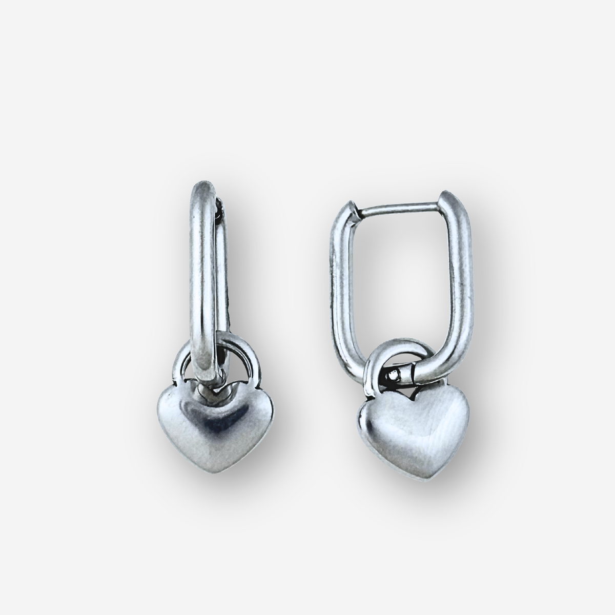 Pair of silver heart-shaped earrings on a light gray background