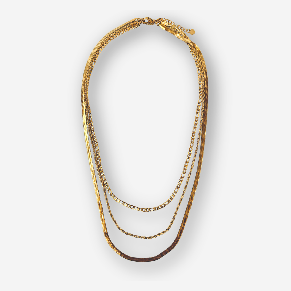 A multi-layered gold chain necklace featuring three distinct chain styles, displayed on a clean light gray background.