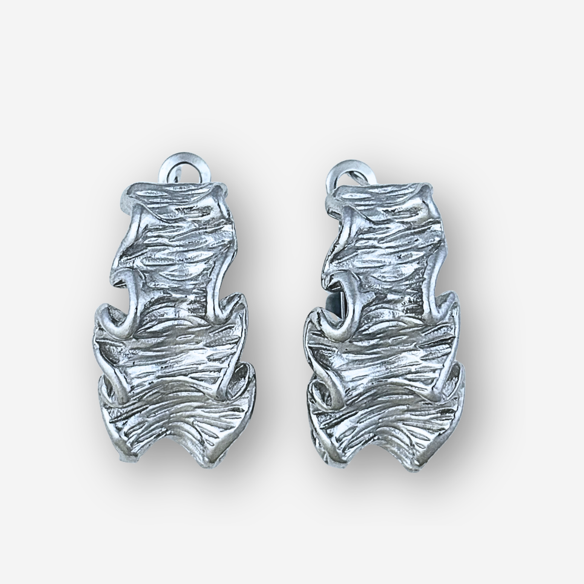 Pair of silver large crinkle earrings on a white background