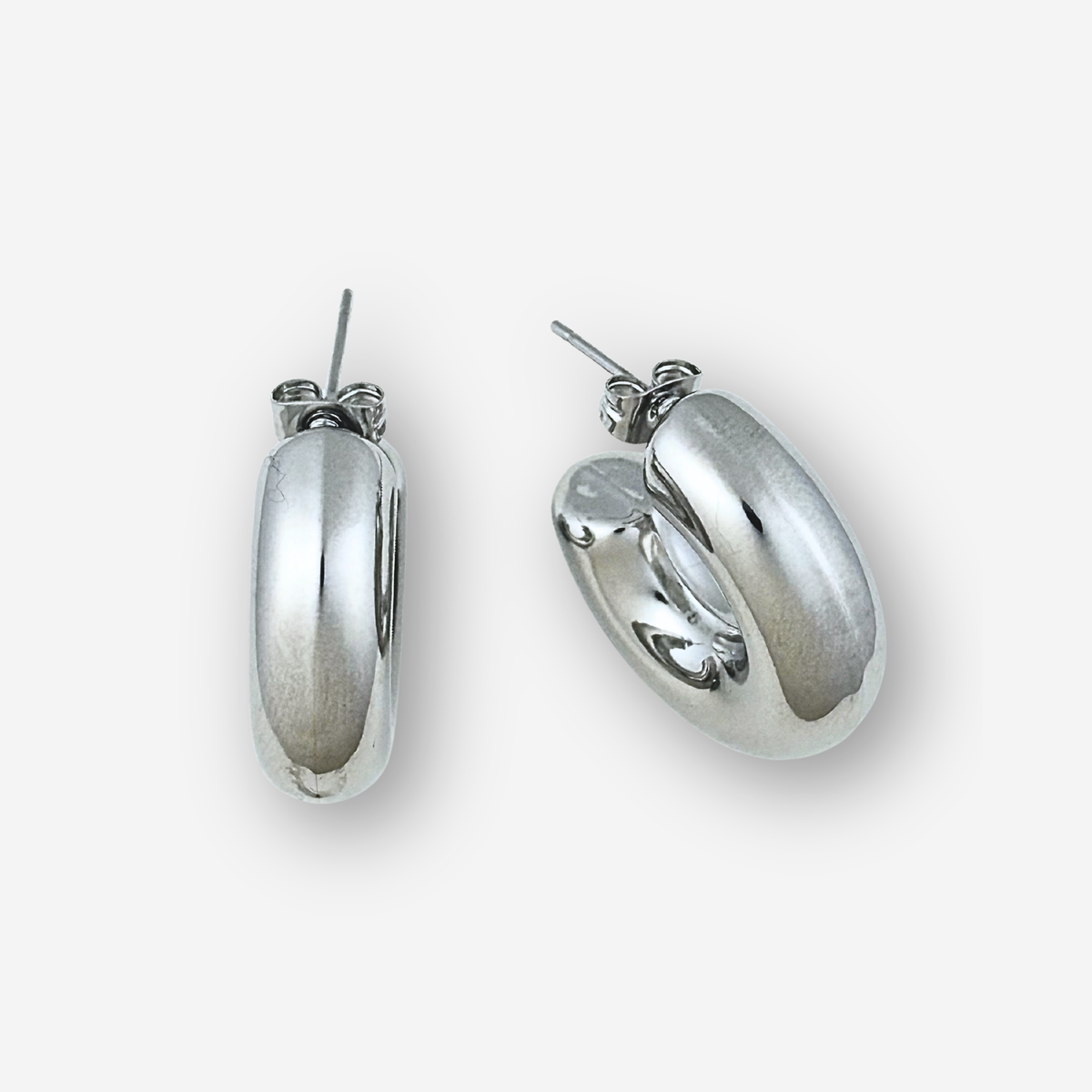 Silver hoop earrings on a light grey background