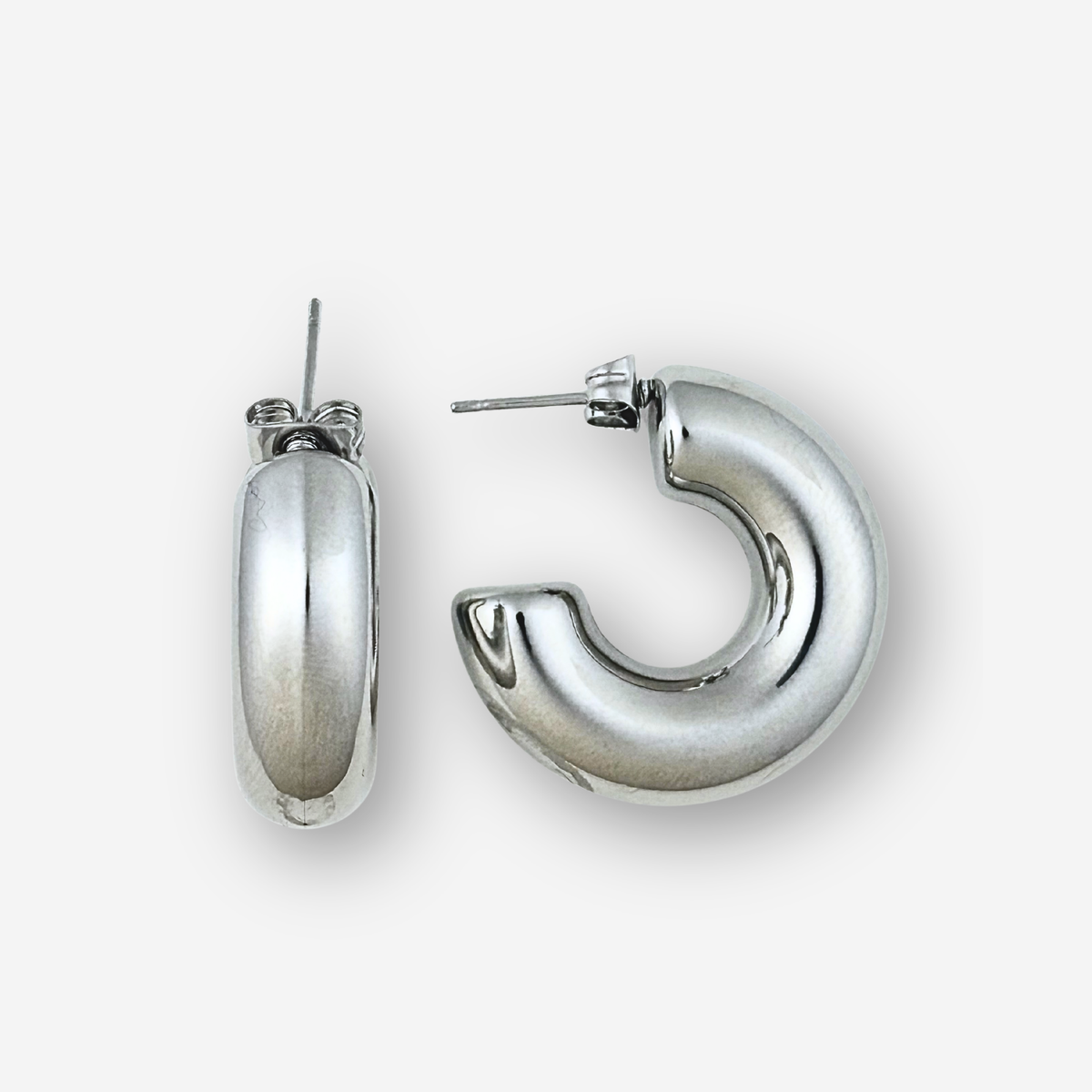 Silver hoop earrings on a light grey background