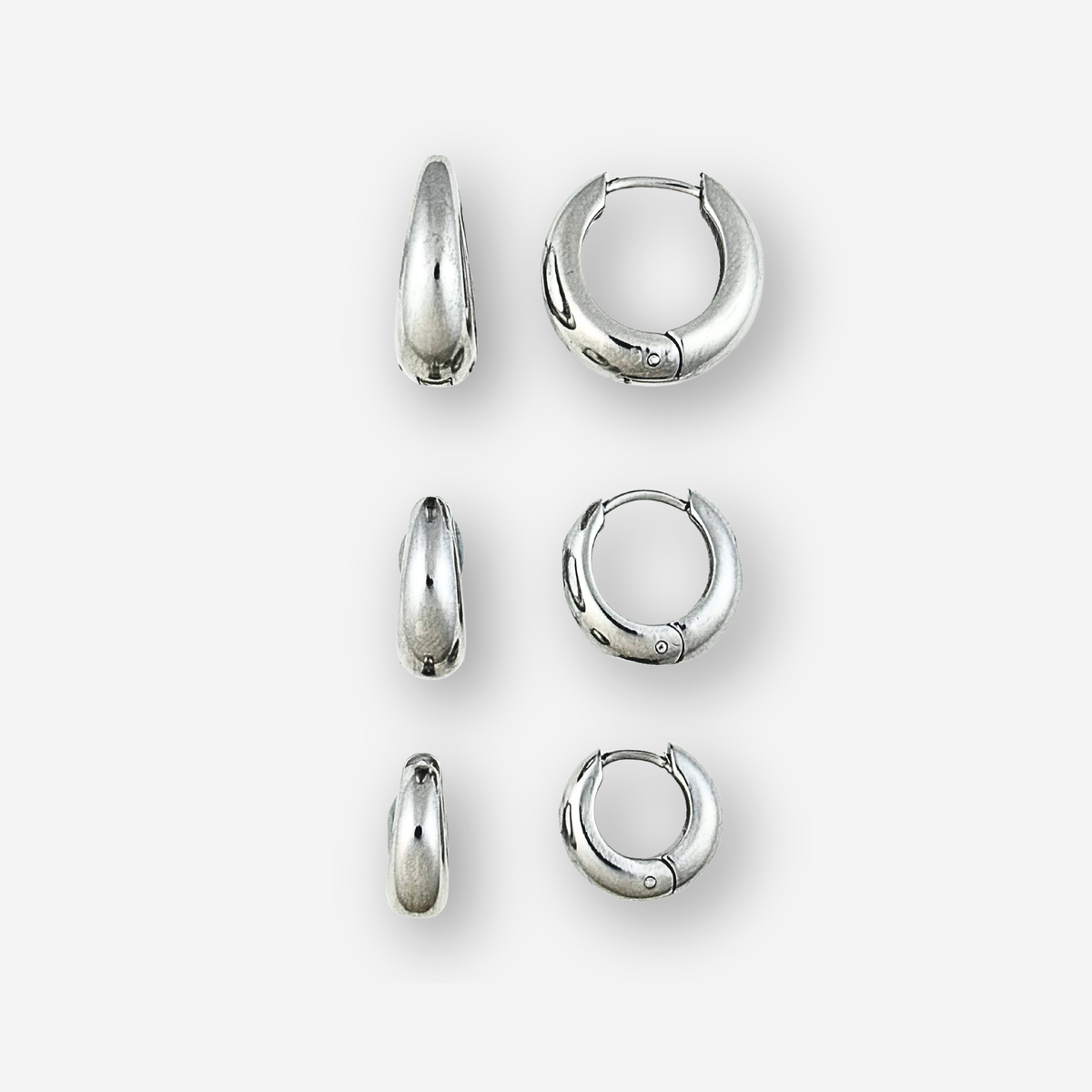 Set of silver hoop earrings on a white background