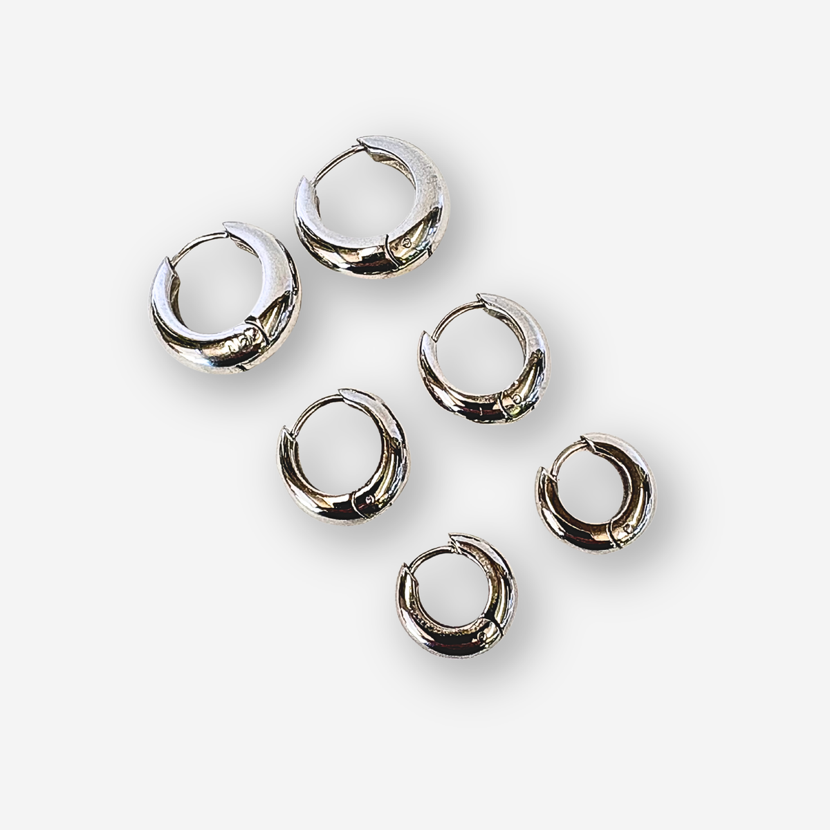 Set of silver hoop earrings on a white background