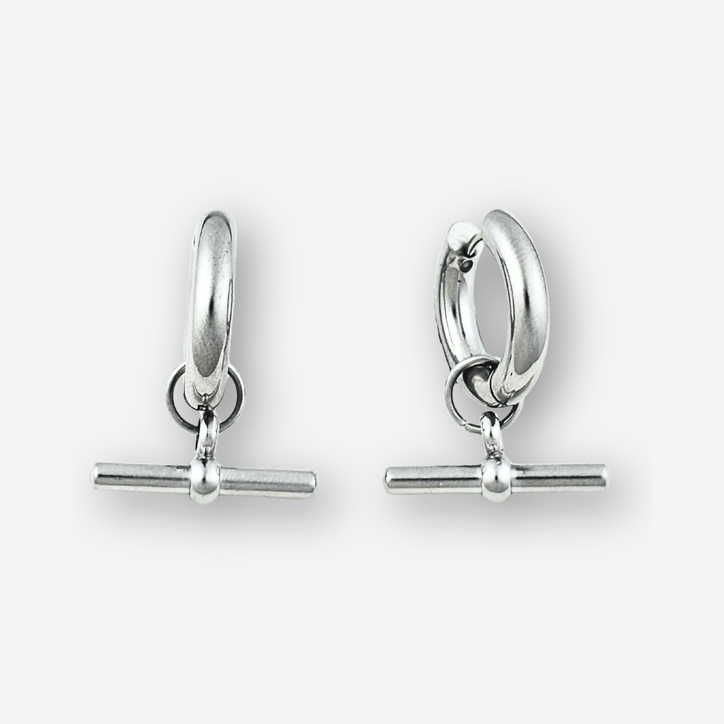 A pair of polished silver huggie hoop earrings with a toggle bar clasp, displayed on a clean light gray background.