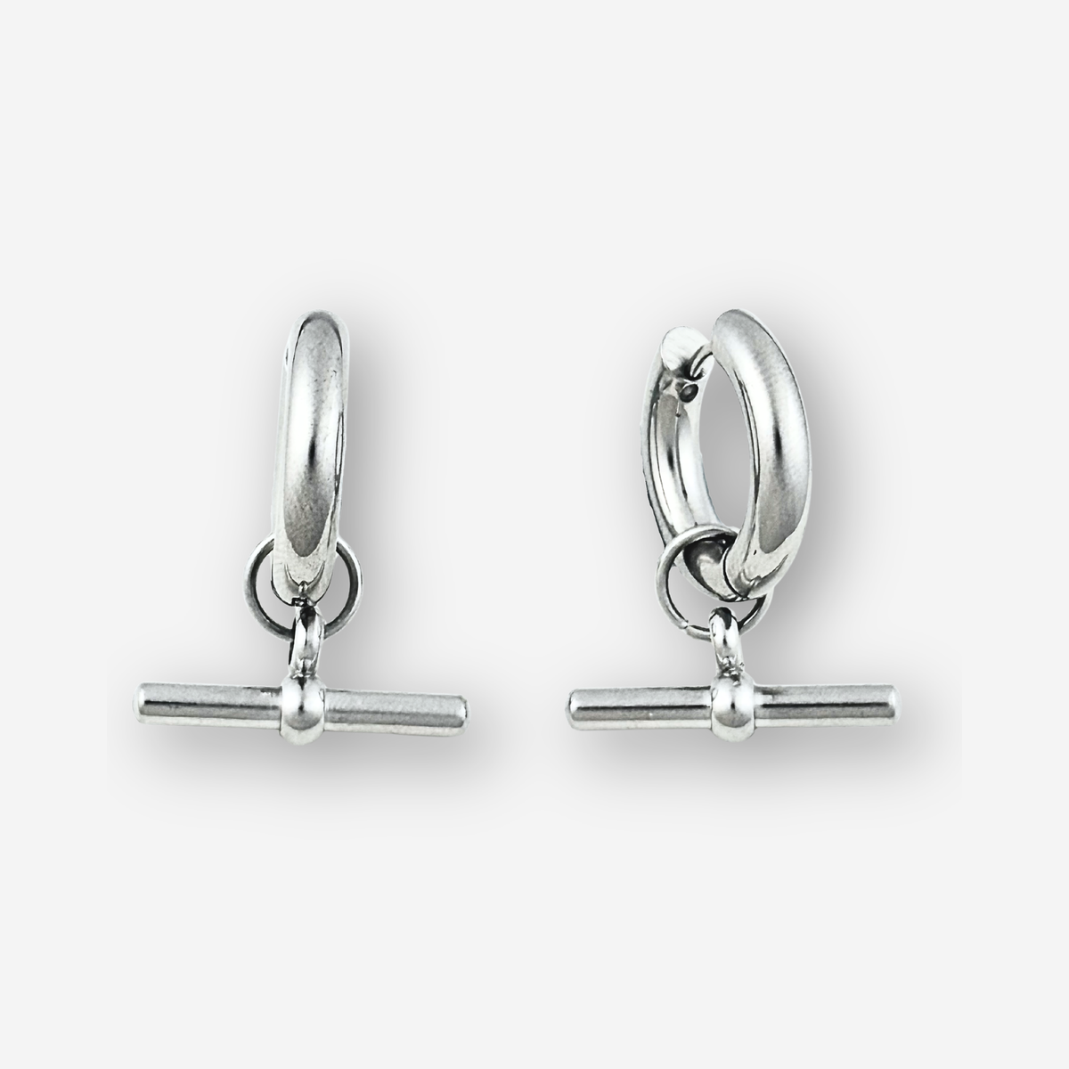 A pair of polished silver huggie hoop earrings with a toggle bar clasp, displayed on a clean light gray background.