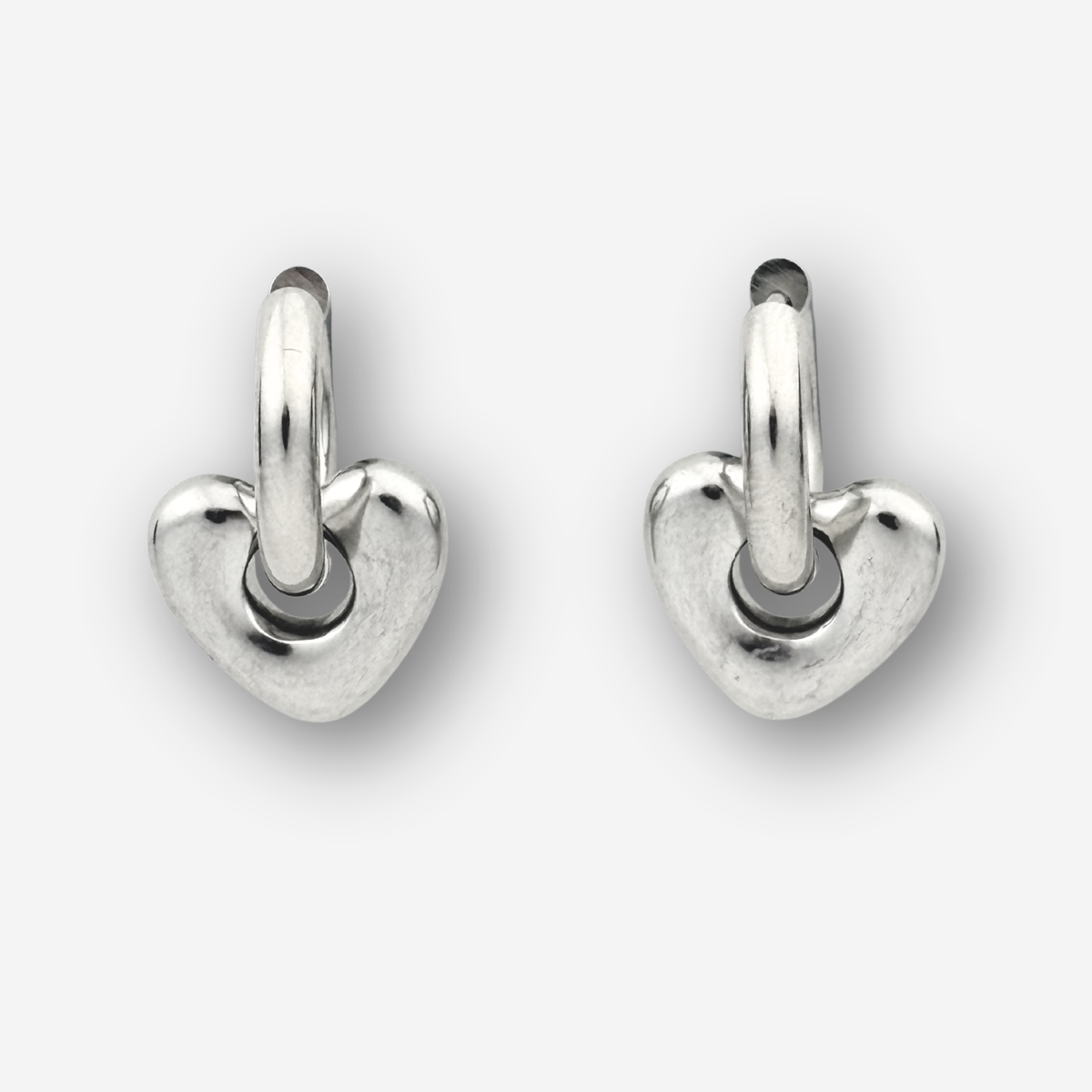 Silver heart shaped hoops on a light grey background