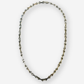 A silver-toned geometric chain necklace with triangular links, displayed in an oval shape against a light gray background.