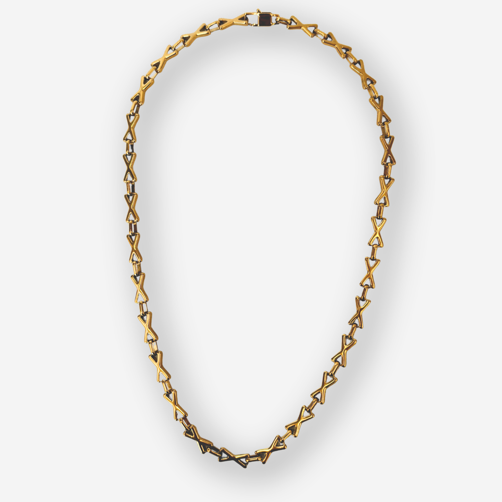 A gold-toned geometric link chain necklace with interlocking triangular links, displayed on a light gray background.