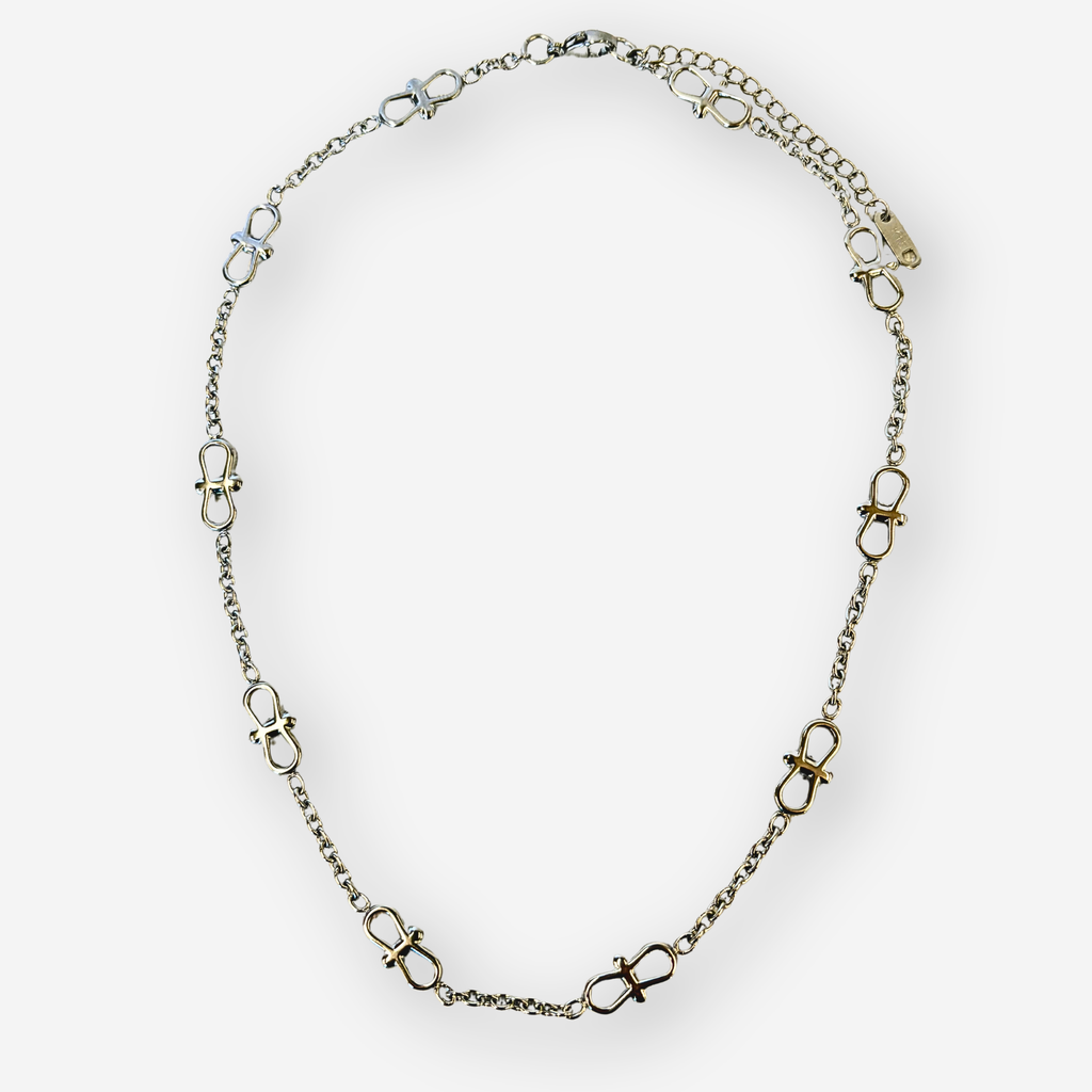 A silver chain necklace featuring infinity links spaced evenly along the chain, displayed on a clean white background.