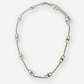 A silver chain necklace featuring infinity links spaced evenly along the chain, displayed on a clean white background.
