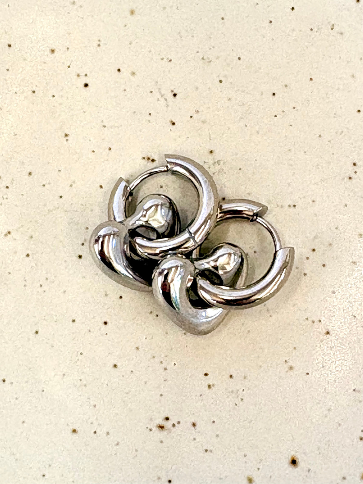 Silver hoop earrings on a beige background