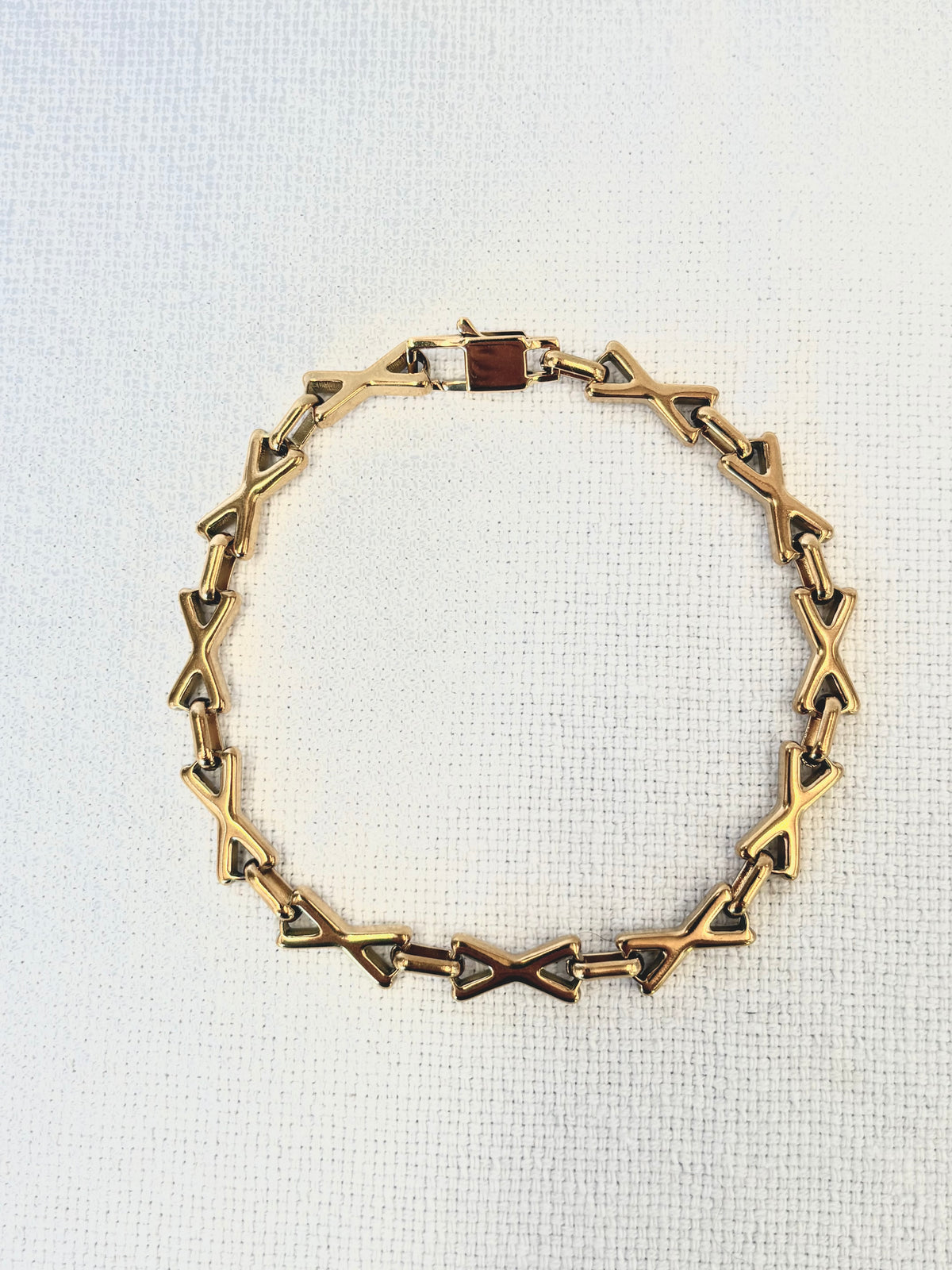 XOXO Gold Bracelet on a neutral background