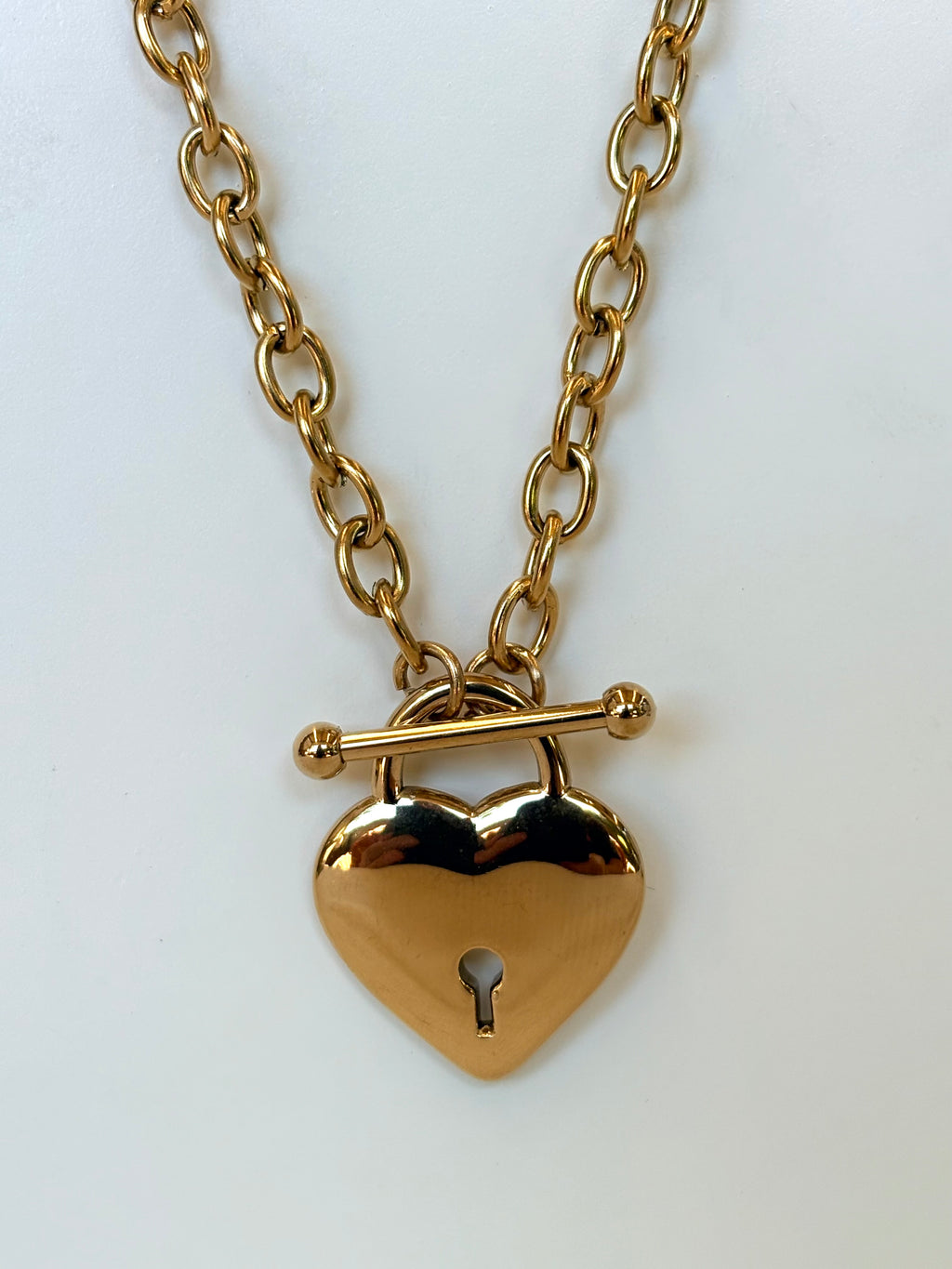 Gold heart-shaped padlock necklace on a white background