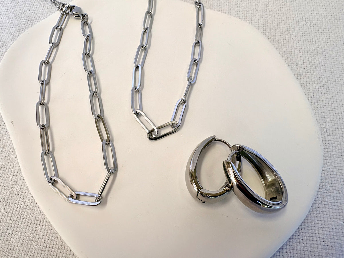 Sienna Paperclip Chain Silver Bracelet styled with hoop earrings on white stand