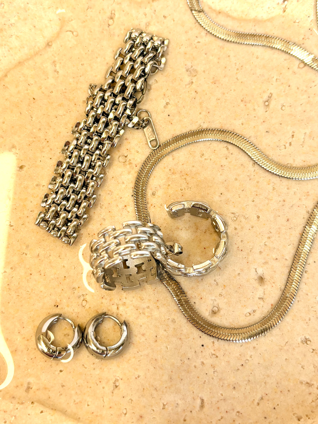 Collection of gold jewelry on a beige surface
