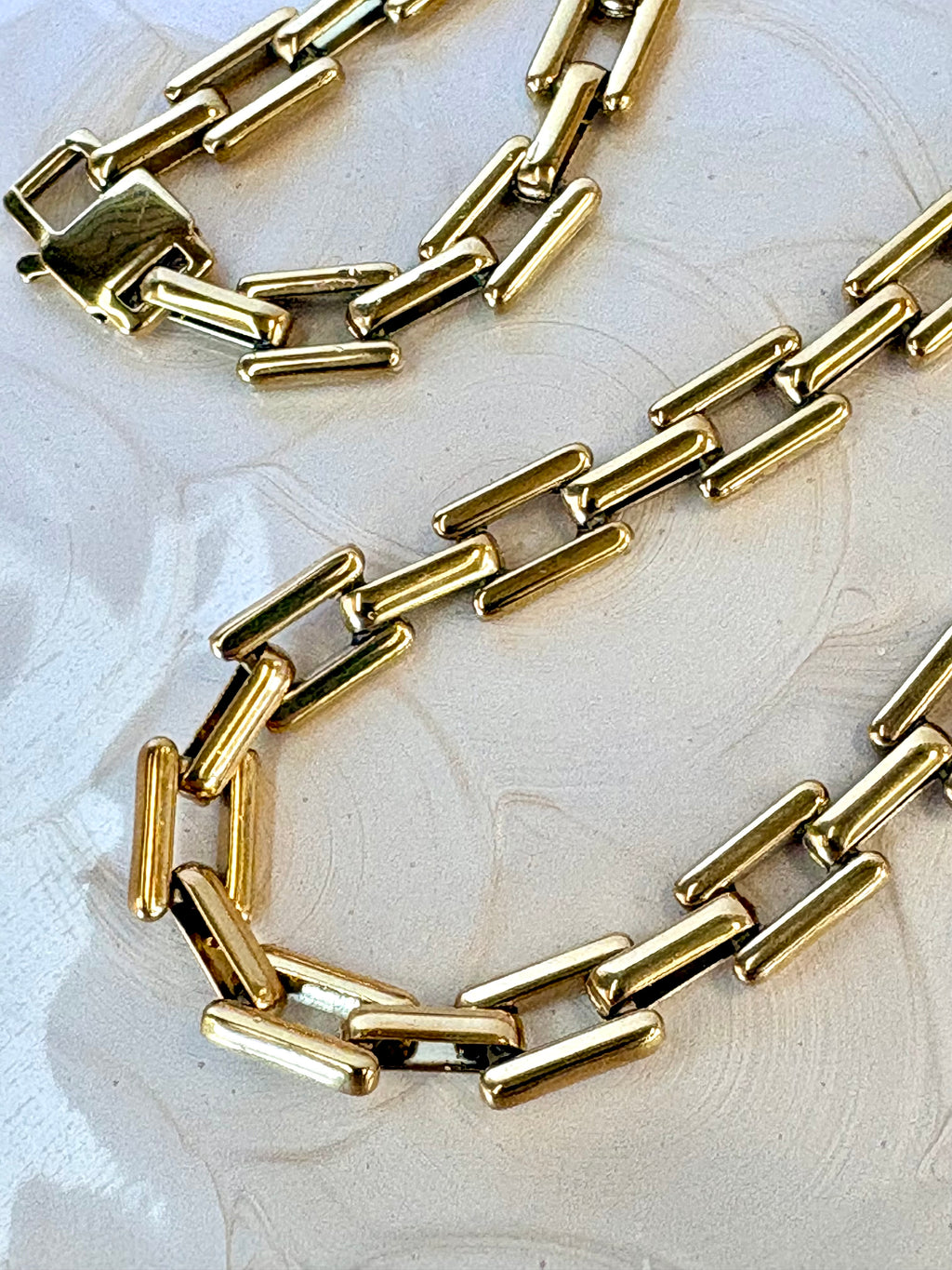 Gold chain necklace on a light background
