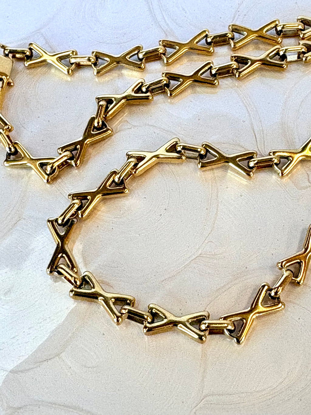Gold chain necklace on a light background