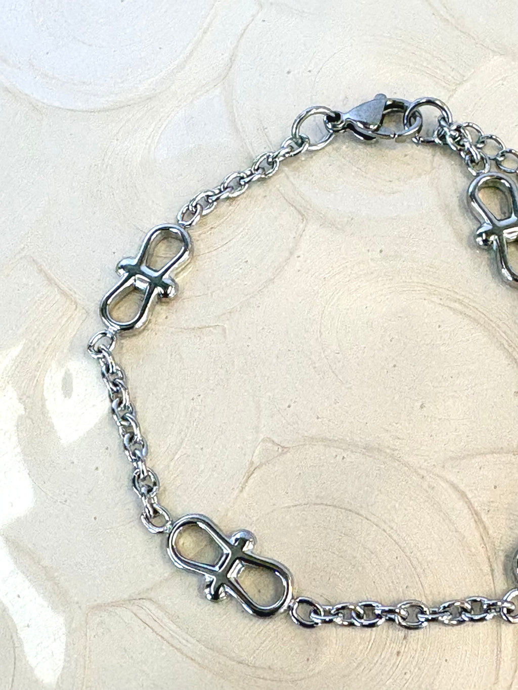 Infinity Chain Silver Bracelet flat lay on neutral background
