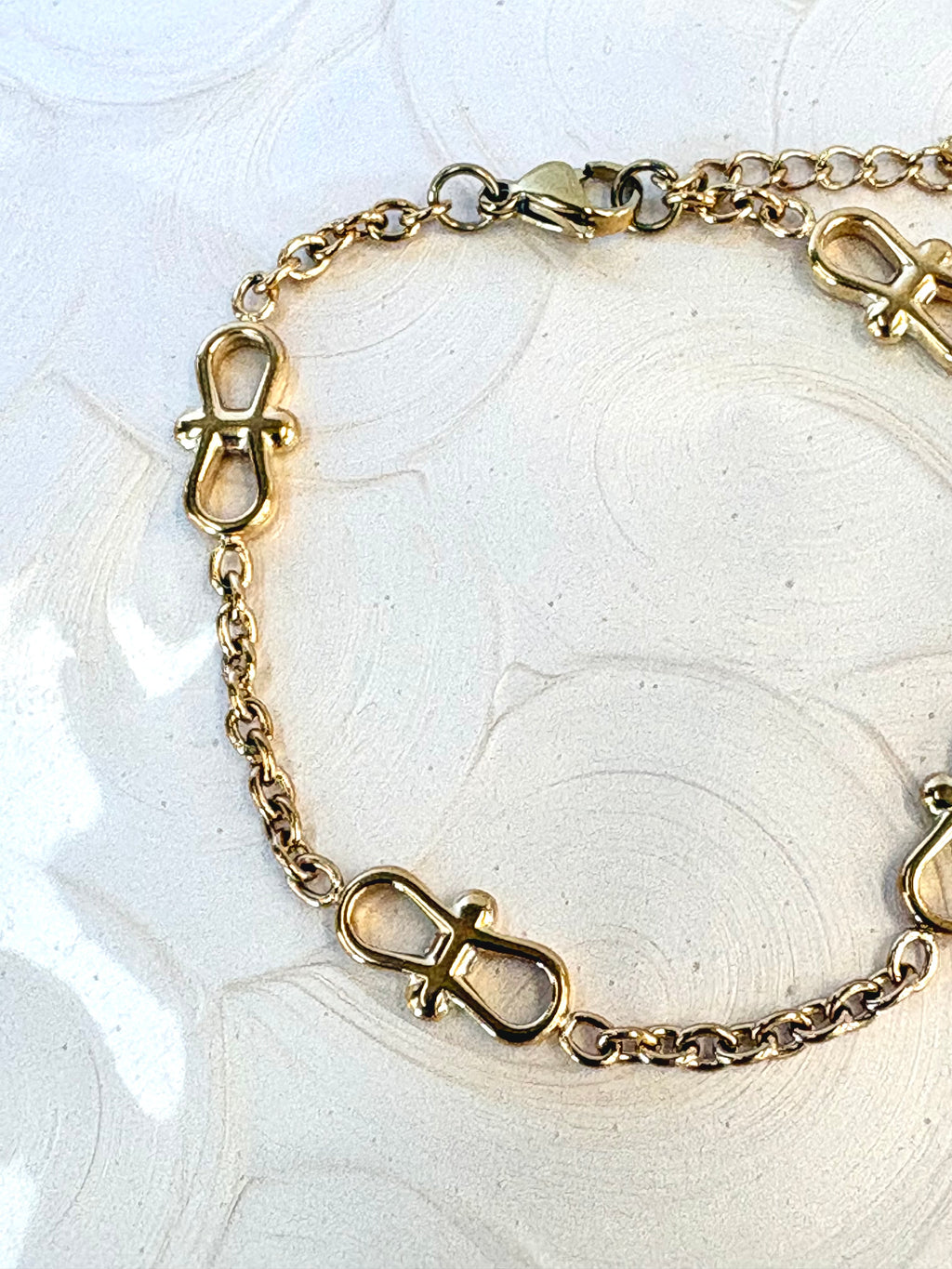 Infinity Chain Gold Bracelet flat lay on neutral background