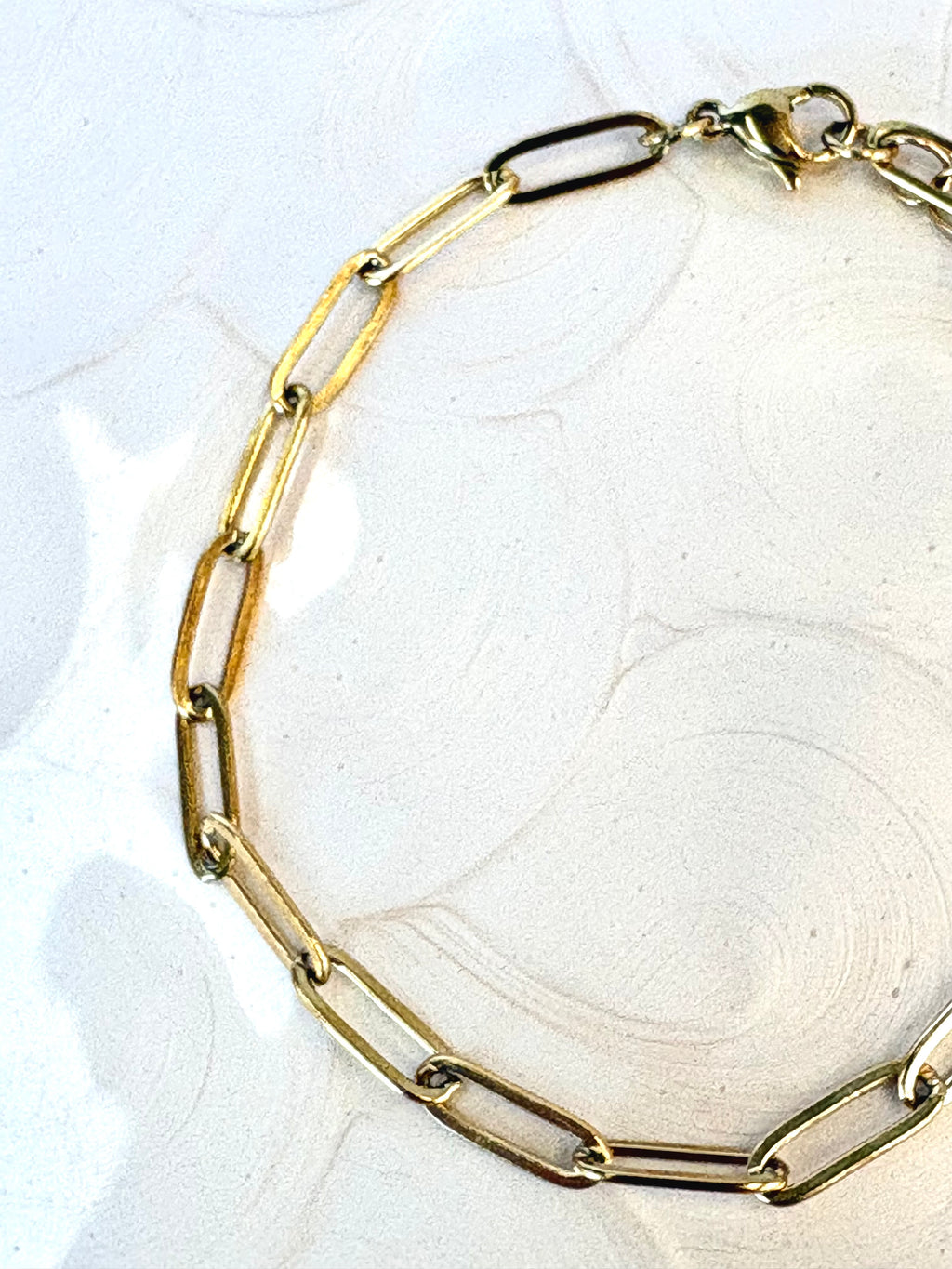Sienna Paperclip Chain Gold Bracelet flat lay on neutral background