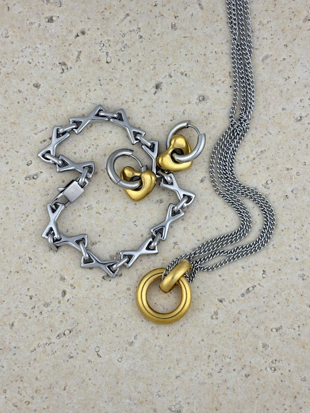 Silver and gold necklace on a textured surface