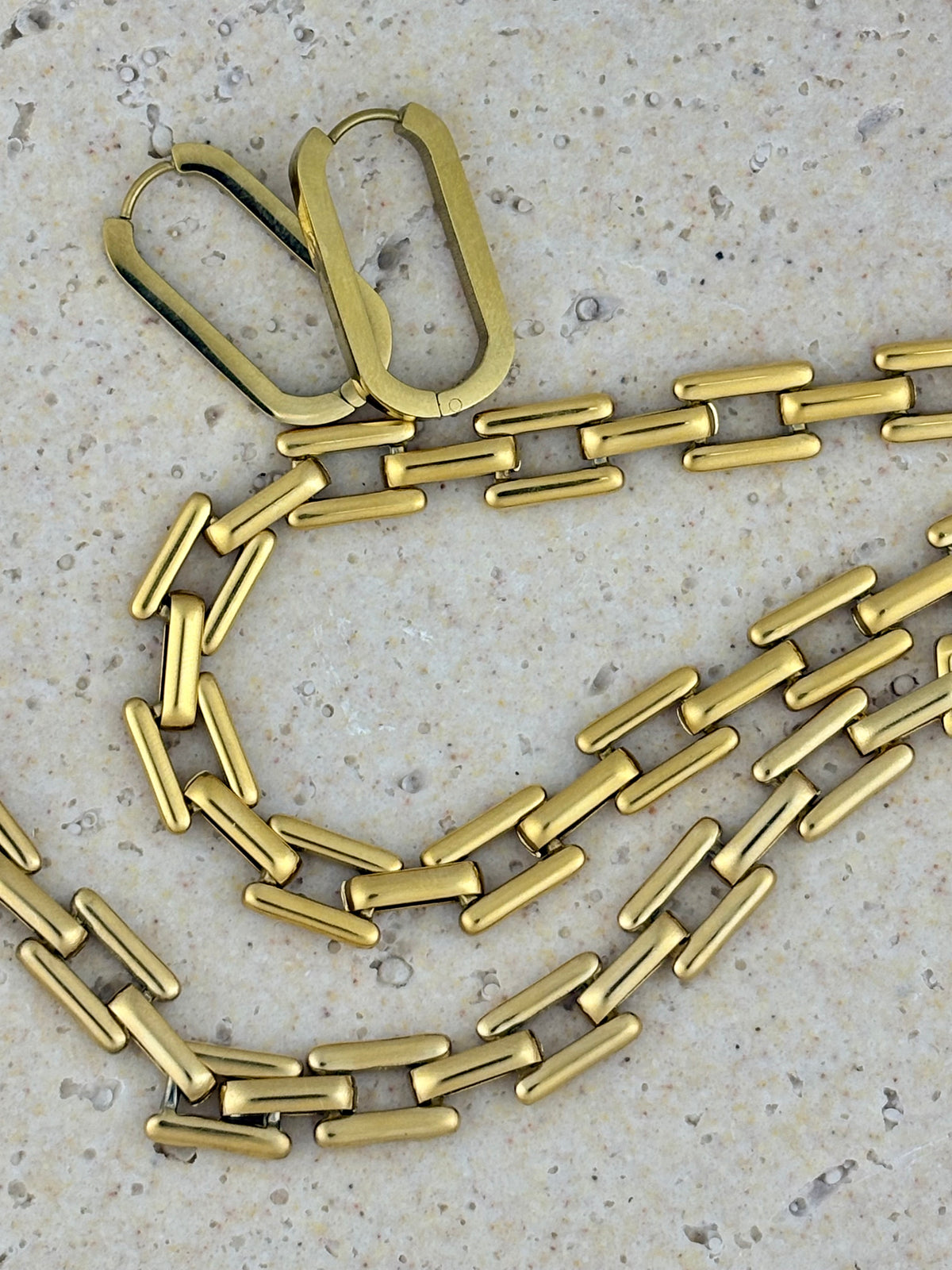 Gold chain necklace on a textured surface