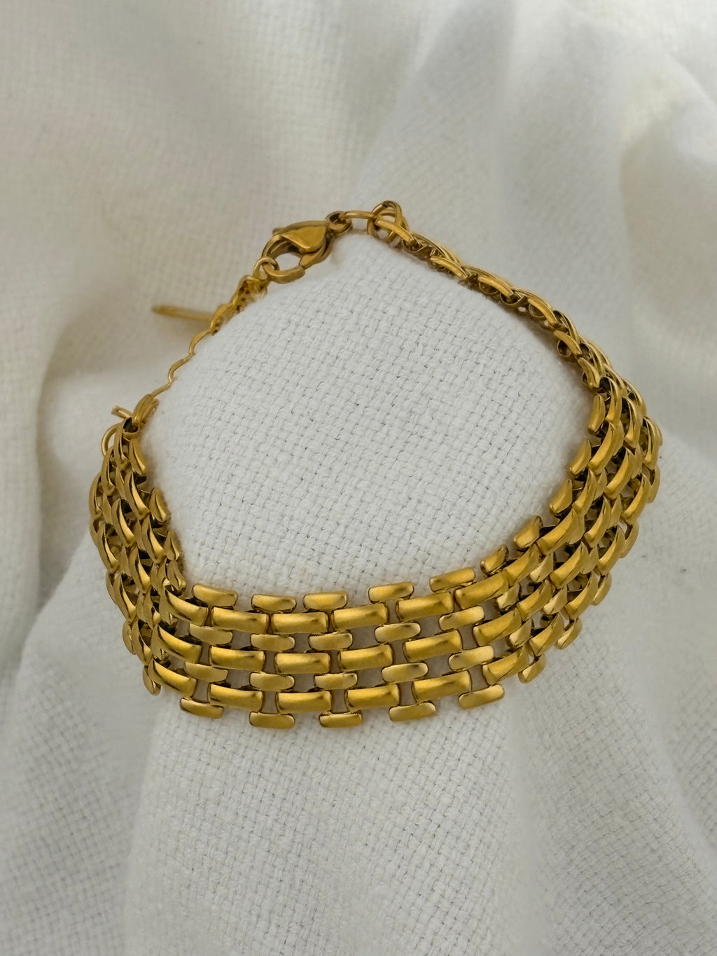 Mackenzie Gold Bracelet on a fabric background